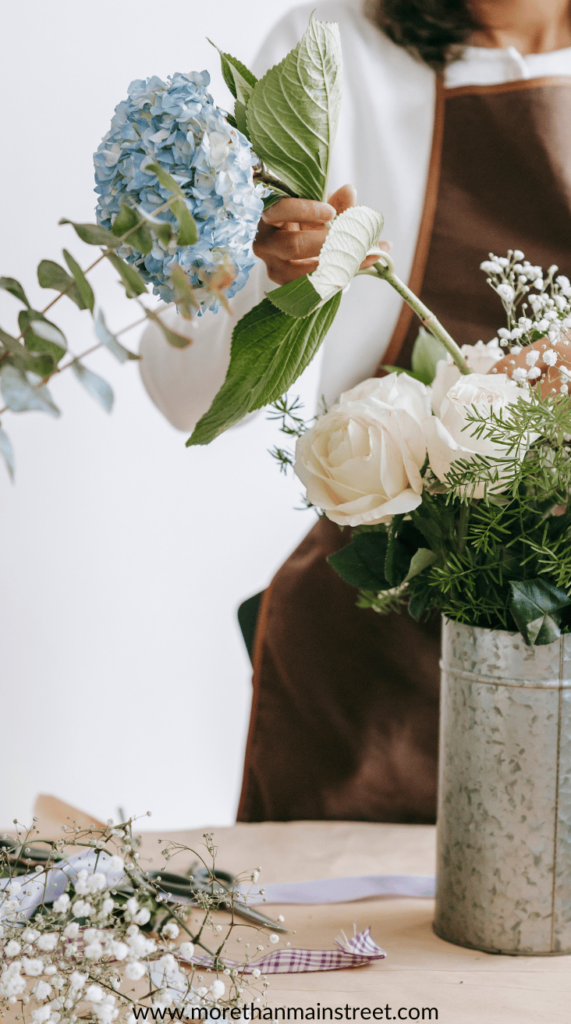 faceless woman arranging flowers in a vase